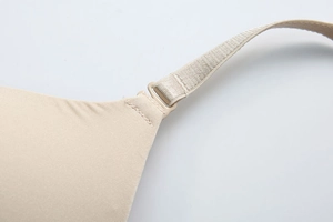 Detail view of seamless beige bra showing smooth fabric and adjustable shoulder strap join