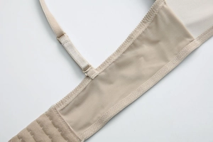 Detail of beige mesh bra wing with adjustable strap and breathable fabric texture