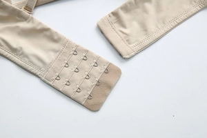 Detail of skin-tone seamless bra showing the four-row hook-and-eye closure and soft fabric