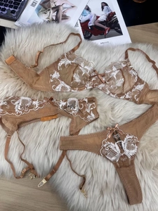Vue à plat détaillée d'un ensemble de lingerie en dentelle marron avec broderie florale blanche
