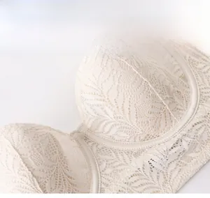 Detailed macro view of cream-colored lace mesh bra showing fine floral patterns and stitching