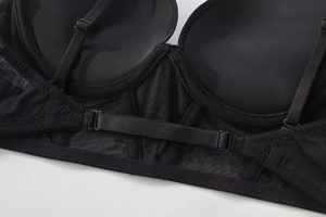 Detail shot of black seamless bra featuring breathable mesh wings and adjustable straps