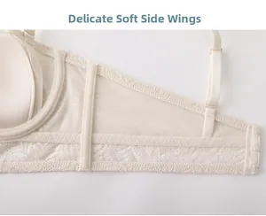 Macro detail of breathable lace side wings on a cream-colored bra with soft mesh fabric