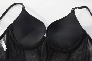 Detail view of black mesh patchwork bra showing washing label and size 75B tag