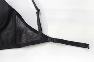 Close-up of black mesh fabric with adjustable strap and metal hardware on seamless bra
