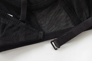 Detail view of U-shaped back closure and mesh straps on black seamless bra