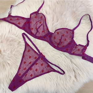 Vue détaillée de l'ensemble de lingerie en maille violette avec motifs de nœuds rouges