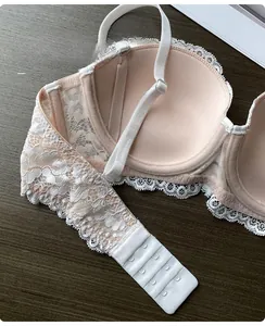 Détail de la fermeture dorsale à quatre rangées et deux boutons sur soutien-gorge rose