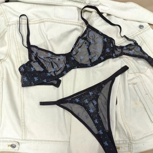 Détails d'un ensemble de lingerie en tulle noir avec motifs nœuds bleus et dentelle