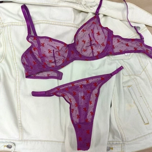 Détails d'un ensemble de lingerie en tulle violet avec imprimés nœuds rouges