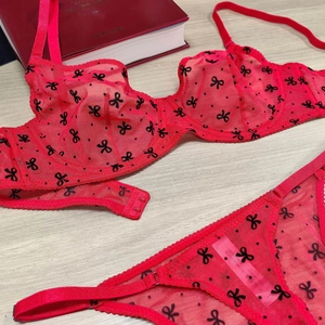 Détails à plat d'un ensemble de lingerie en résille rouge avec motifs nœuds noirs