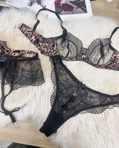 Flat lay of leopard print bra with black lace panties and matching garter belt set