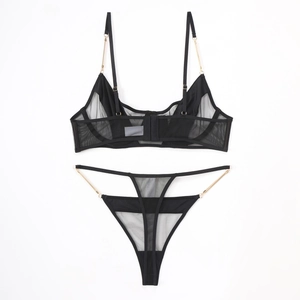 Detail of sheer black mesh lingerie set featuring gold chain straps and metal hardware