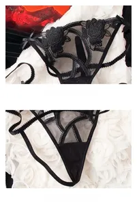 Detail of black lace thong featuring floral rose embroidery and delicate bow accents