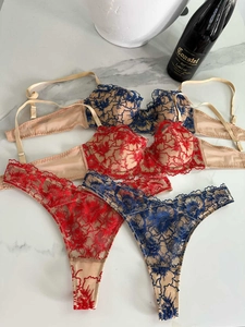 Detailed view of floral embroidery lace lingerie set on marble with wine bottle decor