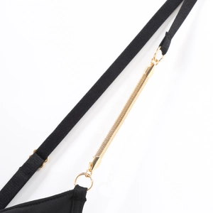 Macro detail of black lingerie strap featuring elegant gold metal chain and connector