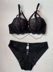 Detailed view of black lace lingerie set with elegant gold metal chain and sheer mesh fabric