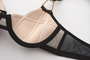 Detailed close-up of breathable mesh fabric and golden metal buckle on lace bra