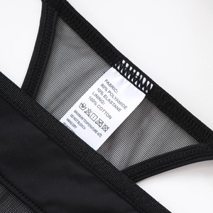 Macro detail of breathable black mesh fabric with care label showing material composition