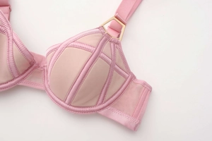 Detailed close-up of pink breathable mesh bra with smooth satin edges and gold metal buckle