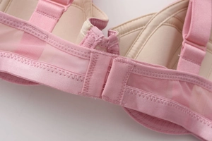 Close-up of pink mesh side wings and adjustable straps on this mesh wired bra