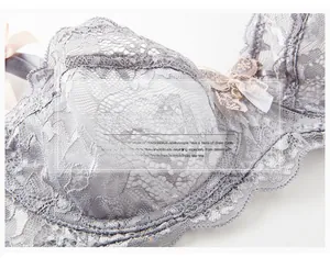 Detailed view of grey hollow lace fabric with delicate pink bow ribbon accent