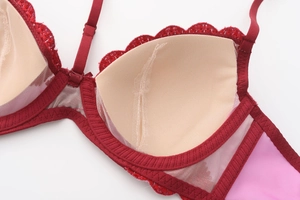 Detail view of red lace bra interior featuring breathable mesh pads and soft stitching