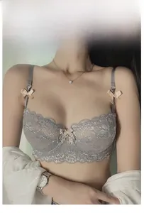 Detail of grey sheer lace bra featuring pink silk bows and a delicate pearl center