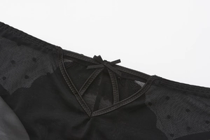 Detail view of black sheer mesh panties with heart polka dots and a satin bow decor