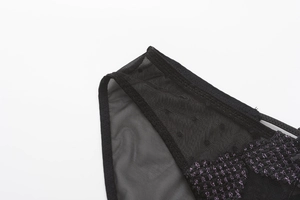 Detailed macro view of black sheer mesh with purple heart embroidery and lace edge