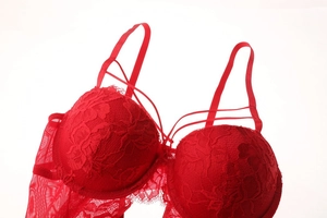 Detail of red floral lace bodysuit with eyelash trim and intricate crisscross straps