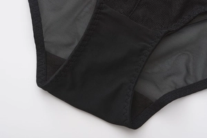 Detailed close-up of breathable black mesh fabric and cotton crotch seam of the panties