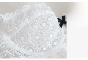 Detailed macro view of white water-soluble lace bra with elegant black bow decoration