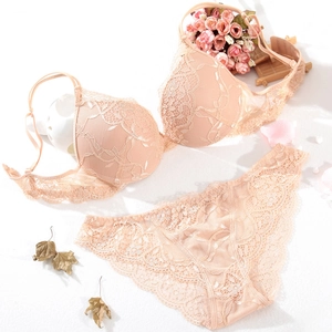 Detailed close-up of nude lace lingerie set featuring floral patterns and scalloped edges