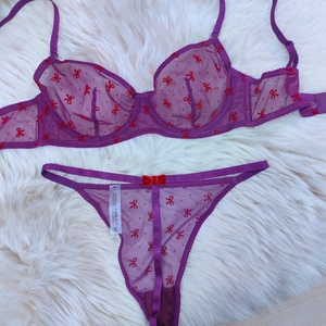 Vue détaillée d'un ensemble lingerie en résille violette avec motifs de nœuds rouges