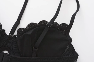 Detail of adjustable straps and floral lace embroidery on black mesh bra