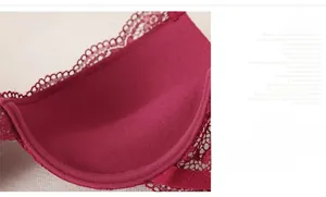 Detail of wine red lace bra featuring thick bottom padding and push-up support structure
