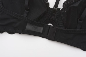 Detail of adjustable straps and rear hook closure on this black lace mesh bra
