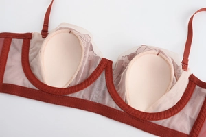 Detail view of deep red lace bra with breathable nude teardrop padding and mesh lining