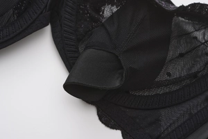 Detail view of black lace bra cup showing inner pocket lining and mesh fabric textures