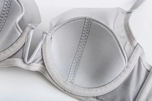 Macro view of light grey mesh bra showing breathable sponge padding and fine stitching details