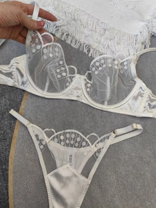 Détail d'un ensemble lingerie dentelle blanche avec mesh transparent et boucles dorées