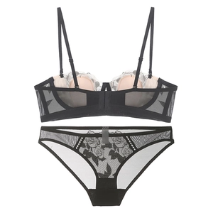 Détail d'un ensemble de lingerie en dentelle noire avec broderie rose et tulle fin