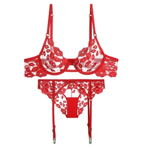 Détail à plat d'un ensemble de lingerie en tulle rouge avec broderie lèvres rouges