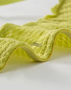 Detail of soft breathable grass green knitted fabric with breathable hollow texture