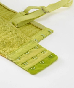 Macro detail of avocado green bra featuring waffle texture and three-row hook-and-eye closure
