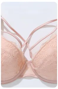 Détail du tissu en dentelle florale rose doux et bretelles croisées sur le soutien-gorge