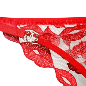 Détail de lingerie en dentelle rouge avec broderie de lèvres et anneaux métalliques