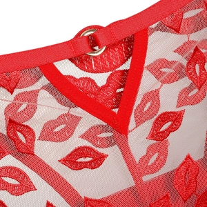 Détail de broderie lèvres rouges sur tulle blanc avec anneau en métal doré chic
