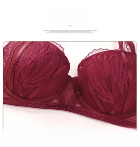 Détail d'un soutien-gorge bordeaux avec dentelle de cils et textures de plumes